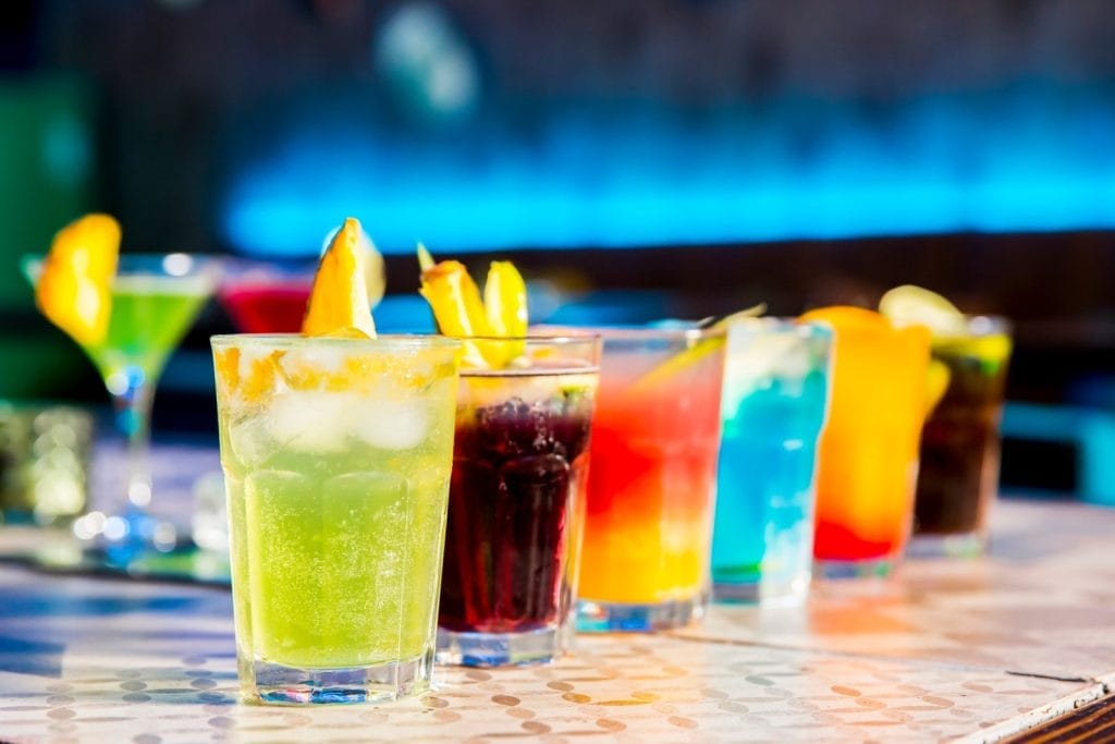 A vibrant display of various cocktails, showcasing a Bahamas cocktail experience with colorful garnishes and glassware.