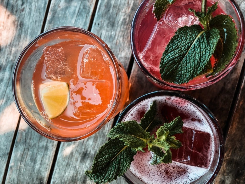 A refreshing glass of homemade lemonade sits on a rustic wooden table, perfect for a Bahamas cocktail experience.