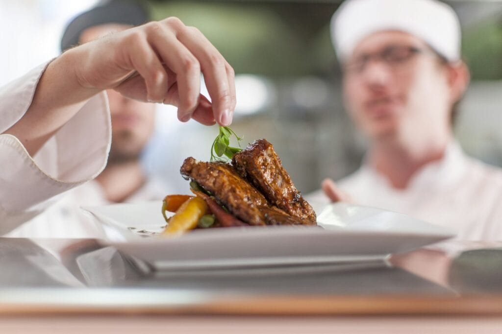 Chef garnishing plate with food