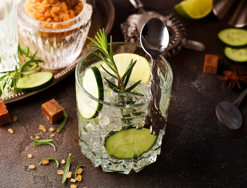 signature cocktails and craft beers - Refreshing gin tonic cocktail with cucumber and rosemary on a dark concrete background,