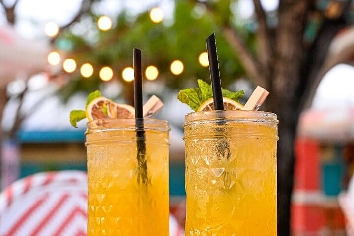 A vibrant cocktail garnished with tropical fruits, showcasing top island cocktail experiences Bahamas in a beach setting.